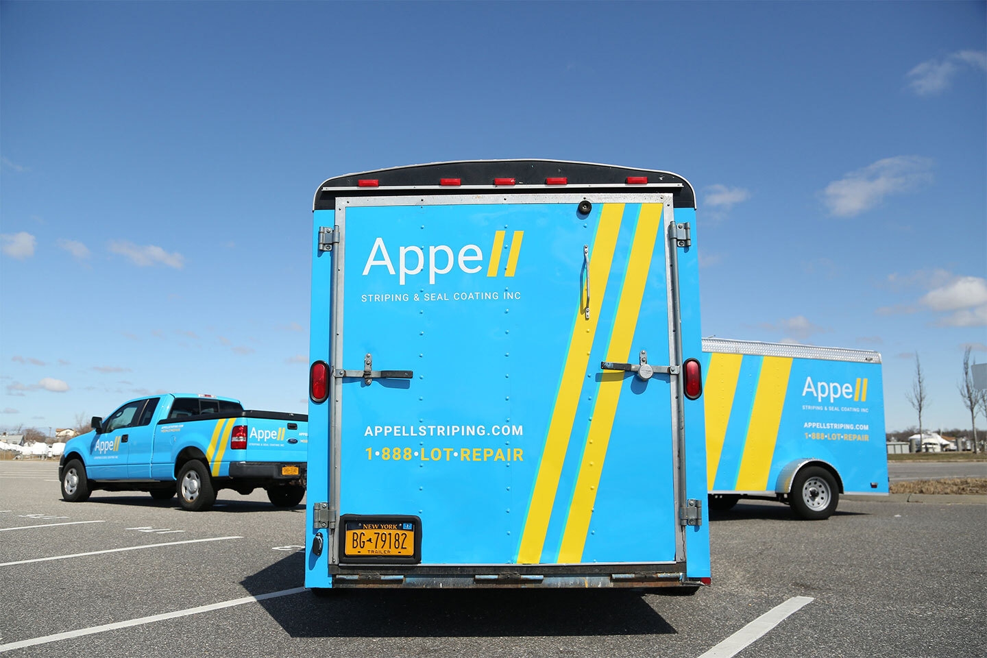A fleet of Appell Striping & Seal Coating Inc. vehicles parked in a lot, showcasing their branding and services.