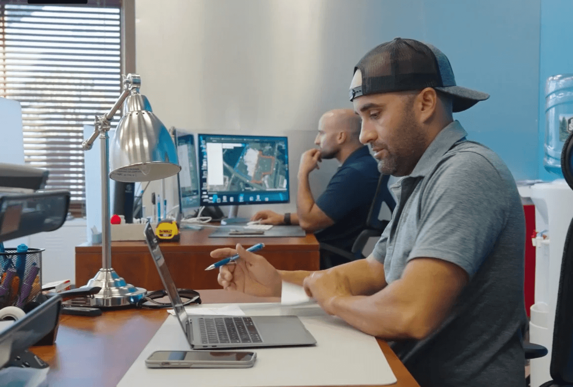 Man working at desk with laptop and documents, focused on task.
