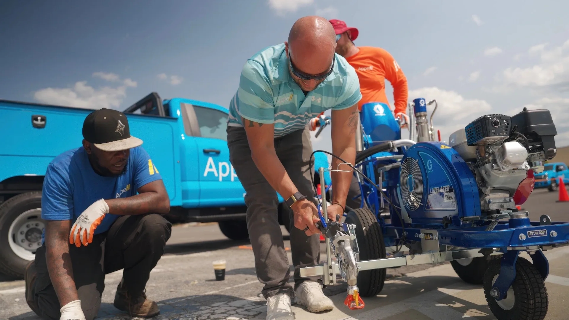 Appell striping line striping franchise team values A franchise team working on a line striping machine, demonstrating teamwork and precision.